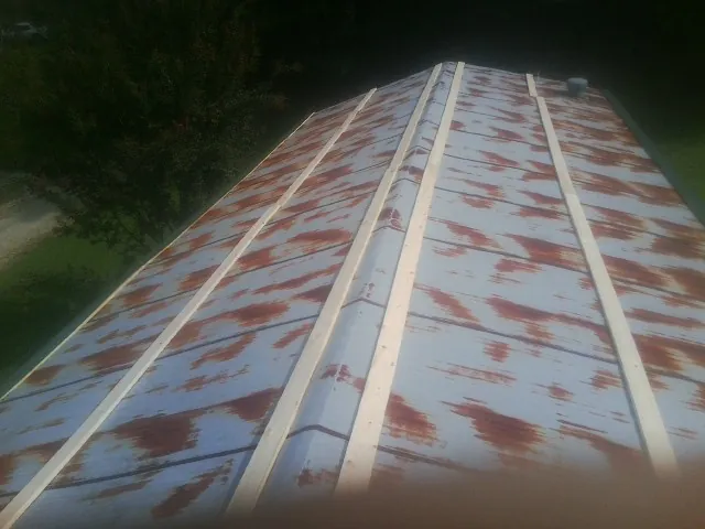 Rusted metal roof panels with new wood purlins before replacement — Storm Damage Roof Repair in Jadwin by Roofing Brothers