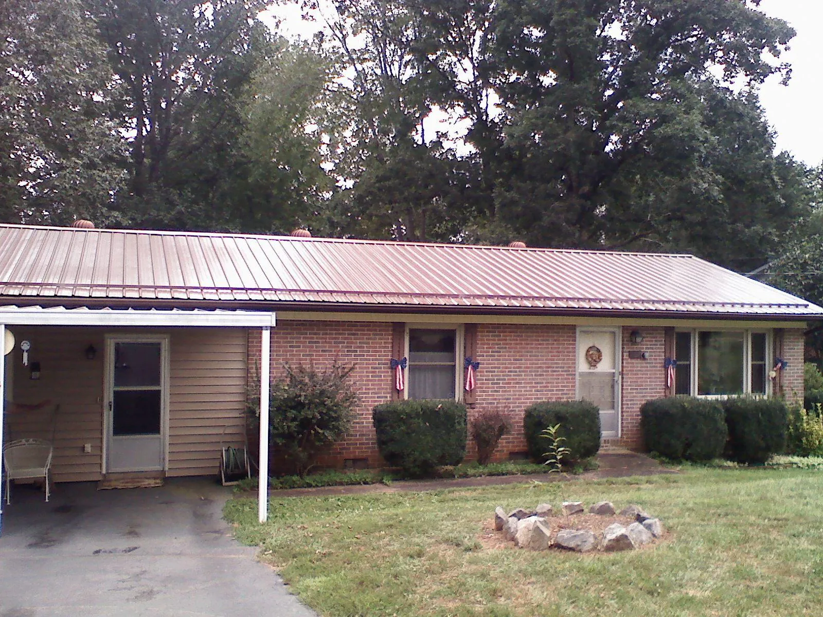 Bronze metal roof and carport on a brick ranch home — Roof Repair work by our crew in Jadwin