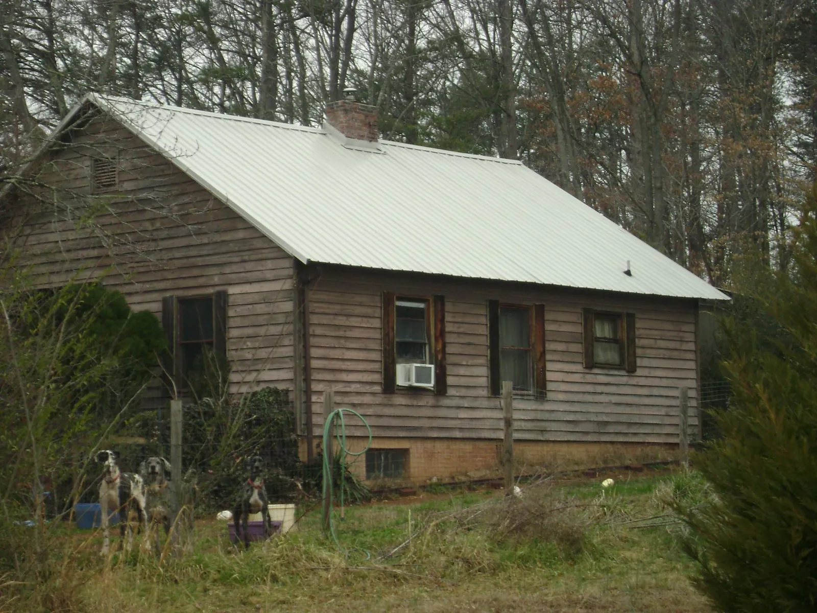 White metal roof on an old wood sided farmhouse, from a Metal Roof Installation job in Jadwin